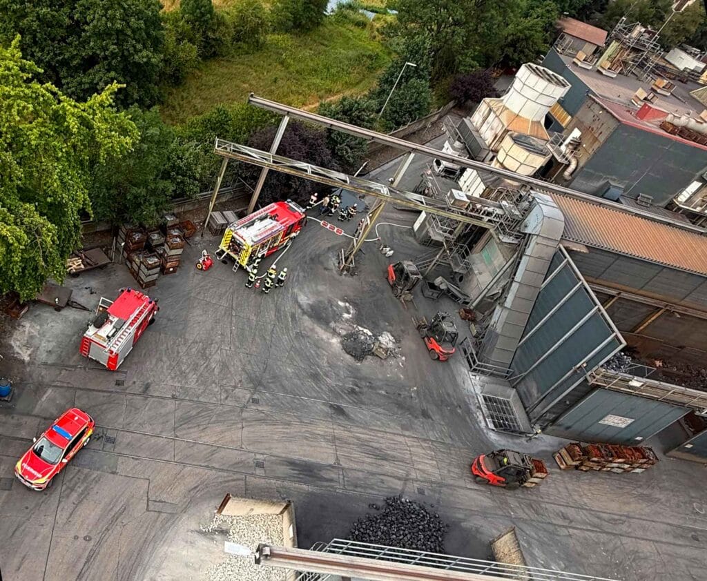 Luftaufnahme der Feuerwehrübung auf dem Werksgelände mit Einsatzfahrzeugen und Feuerwehrkräften.